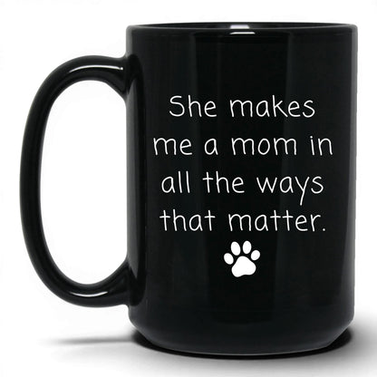 She Makes Me a Mom Mug – 15oz Black Mug