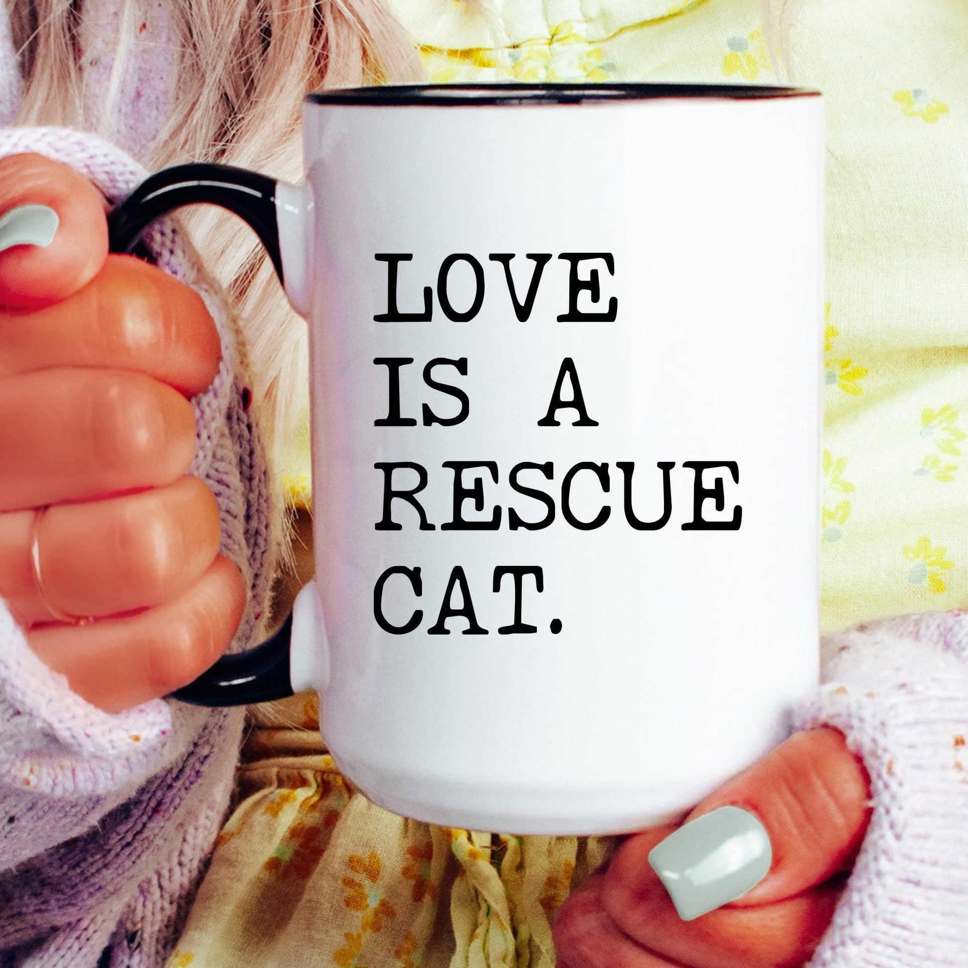 Love Is a Rescue Cat coffee mug held by a model