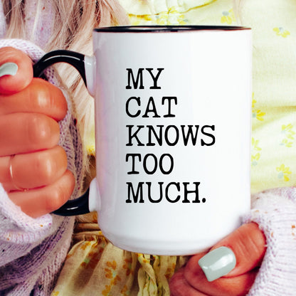 My Cat Knows Too Much coffee mug held by a model